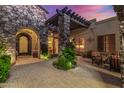 Charming courtyard entry with stone pillars, wrought iron door, and comfortable seating at 37295 N Boulder View Dr, Scottsdale, AZ 85262