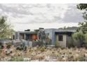 Modern home with stone accents and a backyard patio at 10071 E Aniko Dr, Scottsdale, AZ 85262