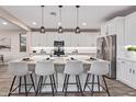 Modern kitchen with white cabinets, quartz countertops, and island seating at 17832 W Sapium Way, Goodyear, AZ 85338