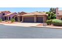 House exterior with tile roof, two-car garage, and manicured landscaping at 5839 E Jensen St, Mesa, AZ 85205