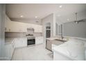 Modern kitchen with white cabinets and stainless steel appliances at 7469 W Monona Dr, Glendale, AZ 85308