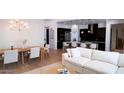 Open concept dining area with modern chandelier and white sofa at 100 W Northern Ave # 2, Phoenix, AZ 85021