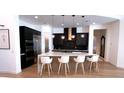 Modern kitchen with dark cabinetry, quartz countertops, and island at 100 W Northern Ave # 2, Phoenix, AZ 85021