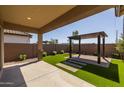 Covered patio with artificial turf and pergola at 22427 E Oriole Way, Queen Creek, AZ 85142