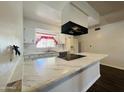 White kitchen with marble countertops and black appliances at 2814 N 55Th Ave, Phoenix, AZ 85035