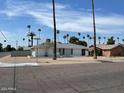 House with a large front yard and palm trees in a residential neighborhood at 1701 W Highland Ave, Phoenix, AZ 85015