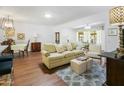 Living room with light beige couch and wood flooring at 9701 W Oak Ridge Dr, Sun City, AZ 85351