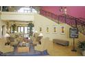 Elegant community clubhouse with comfortable seating and grand staircase at 20620 N Confetti Ct, Maricopa, AZ 85138