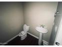 Small half bathroom with pedestal sink and toilet at 41041 W Somers Dr, Maricopa, AZ 85138