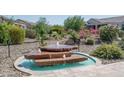 Landscaped backyard with a tiered rock water fountain at 26085 W Siesta Ln, Buckeye, AZ 85396