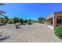 Spacious backyard with gravel and mature plants at 17041 W Artesia Dr, Surprise, AZ 85387