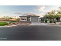 New construction home with gray exterior, two-car garage and desert landscaping at 9625 E Solina Ave, Mesa, AZ 85212