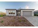 Modern home with gray exterior, two-car garage, and nicely landscaped front at 9625 E Solina Ave, Mesa, AZ 85212