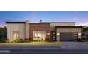 Modern home exterior with stone and wood accents, landscaping, and two-car garage at 4302 E Marion Way, Phoenix, AZ 85018