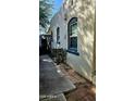 View of the side of a house with stucco walls, blue-framed windows and a walkway at 2322 N 8Th St, Phoenix, AZ 85006
