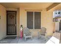 Covered porch with seating, welcome sign, and wreath at 21527 N 78Th Ln, Peoria, AZ 85382