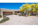 Luxury home exterior with wooden garage door and desert landscaping at 11166 E Prospect Point Dr, Scottsdale, AZ 85262