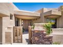 Front entry with wooden gate and stone accents at 11166 E Prospect Point Dr, Scottsdale, AZ 85262