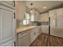 Modern kitchen with white cabinets, white subway tile backsplash and wood-look flooring at 650 N Hawes Rd # 4409, Mesa, AZ 85207