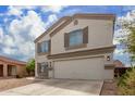 Two story home with beige exterior, brown shutters, and a two car garage at 42999 W Samuel Dr, Maricopa, AZ 85138
