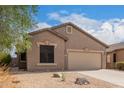 Tan house with two-car garage and desert landscaping at 6599 E Casa De Leon Ln, Gold Canyon, AZ 85118