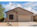 Tan house with two-car garage and desert landscaping at 6599 E Casa De Leon Ln, Gold Canyon, AZ 85118
