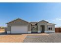 New construction home with a two-car garage and brick driveway at 13563 S Huntington Rd, Arizona City, AZ 85123