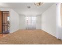 Bright living room with neutral carpeting and a chandelier at 45993 W Dutchman Dr, Maricopa, AZ 85139