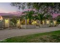 Single-story home exterior with stone accents, palm trees, and a charming front entrance at 7642 N 177Th Ave, Waddell, AZ 85355