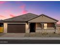 Tan house with brown garage door, a covered porch, and landscaping at 4634 N 177Th Dr, Goodyear, AZ 85395