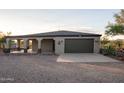 Single story home with covered patio, garage, and desert landscaping at 43630 N 20Th St, New River, AZ 85087