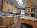 Kitchen features light wood cabinets and skylight at 8700 E University Dr # 1931, Mesa, AZ 85207