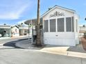 White single-wide mobile home with covered porch and landscaped yard at 1051 S Quartz Dr, Apache Junction, AZ 85119