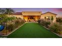 Landscaped backyard with artificial turf and pathway leading to a covered patio at 30416 N 64Th St, Cave Creek, AZ 85331