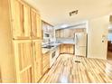 Kitchen with light wood cabinets, white appliances, and laminate floors at 9427 E University Dr # 100, Mesa, AZ 85207