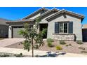 One-story home with gray siding, stone accents, and landscaping at 15922 W Electra Ln, Surprise, AZ 85379