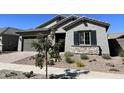 One-story home with gray siding, stone accents, and landscaping at 15922 W Electra Ln, Surprise, AZ 85379