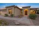 Well-lit entrance to a single-story home with a decorative fountain at 42929 W Castle Cove Cir, Maricopa, AZ 85138