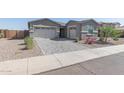 Two-car garage and landscaped front yard with roses at 22207 N Daniel Dr, Maricopa, AZ 85138