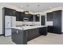 Spacious kitchen featuring dark cabinetry, marble countertops and large island at 31214 N 167Th Ave, Surprise, AZ 85387