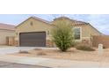 Tan house with a tile roof, two-car garage, and mature shrub at 1134 E Palm Parke Blvd, Casa Grande, AZ 85122