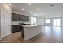 Modern kitchen with dark gray cabinets, granite countertops, and island at 40040 W Bravo Dr, Maricopa, AZ 85138