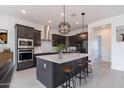 Modern kitchen with dark cabinetry, large island, and stainless steel appliances at 18083 W Amber Dr, Goodyear, AZ 85338