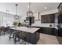 Modern kitchen with dark cabinetry, large island, and stainless steel appliances at 18083 W Amber Dr, Goodyear, AZ 85338