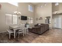 Spacious living room with hardwood floors, a dining area, and a large TV at 16079 W Williams St, Goodyear, AZ 85338