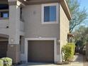 Two-car garage with dark brown doors and landscaping at 14000 N 94Th St # 1037, Scottsdale, AZ 85260