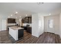 Modern kitchen with dark cabinets, granite counters, and island at 675 W Crowned Dove Trl, Casa Grande, AZ 85122