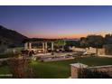 Serene backyard oasis with pergola, fire pit, and expansive lawn at 10493 E Rimrock Dr, Scottsdale, AZ 85255