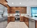 Modern kitchen with stainless steel appliances and wood cabinets at 24614 N 169Th Dr, Surprise, AZ 85387