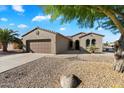 Single-story home with a two-car garage and nicely landscaped front yard at 16419 W Chuparosa Ln, Surprise, AZ 85387